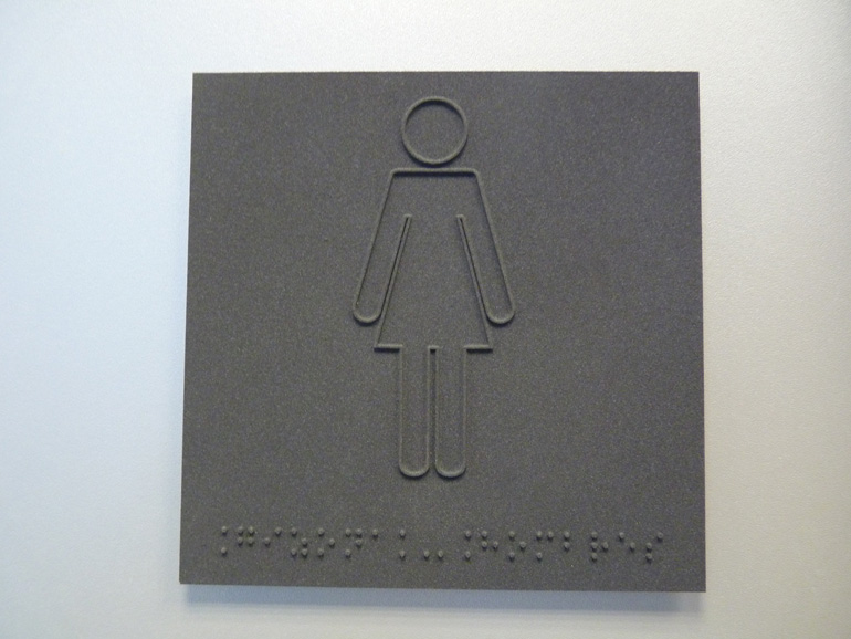 Cartel Braille. Señaletica. Chica